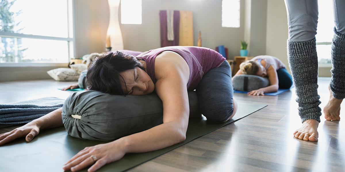 Woman,Using,Bolster,In,Restorative,Yoga,Childs,Pose